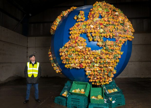 Gregg Wallace next to a food waste planet for Food Waste Action Week