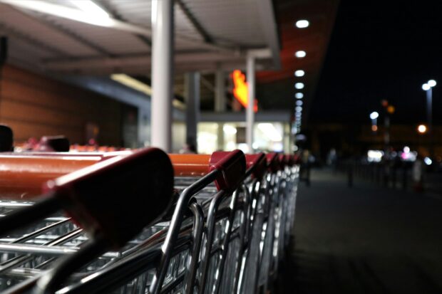 Parked trollies outside a supermarket at night